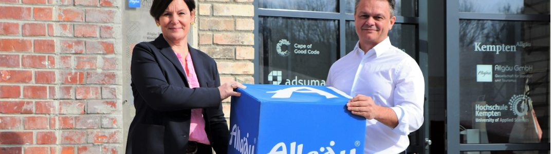 Antonia Widmer from Allgäu Digital holding a big blue Allgäu dice together with Harald Ostler the CEO of aumentoo