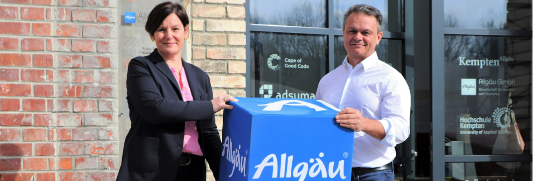 Antonia Widmer from Allgäu Digital holding a big blue Allgäu dice together with Harald Ostler the CEO of aumentoo